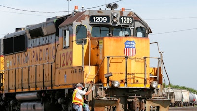 In this July 20, 2017, file photo, a Union Pacific employee climbs on board a locomotive in a rail yard in Council Bluffs, Iowa. One of Union Pacific’s main unions is threatening to strike if the railroad doesn’t do more to protect its employees from the coronavirus.