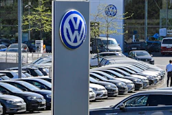 In this April 20, 2020 file photo, a Volkswagen car dealer is open in Essen, Germany. In times when a pandemic unleashes death and poverty, the concept of what is essential to keep society functioning in a lockdown is gripping Europe. What may stay open in one country may be designated as non-essential just across the border.