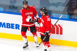 Canada's Braden Schneider (2) and Philip Tomasino (26) celebrate a goal against Switzerland during the first period of an IIHF World Junior Hockey Championship game in Edmonton, Alberta, Dec. 29, 2020.