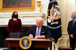 President Joe Biden signs executive orders after speaking about the coronavirus, accompanied by Vice President Kamala Harris, left, and Dr. Anthony Fauci, director of the National Institute of Allergy and Infectious Diseases, right, in the State Dinning Room of the White House, Thursday, Jan. 21, 2021, in Washington.