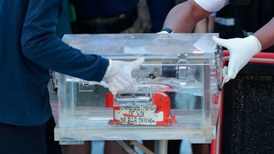 Members of the National Transportation Safety Committee carry a box containing the flight data recorder from the Sriwijaya Air flight SJ-182 retrieved from the Java Sea where the passenger jet crashed at the Tanjung Priok Port, Tuesday, Jan. 12, 2021. Indonesian navy divers searching the ocean floor on Tuesday recovered the flight data recorder from a Sriwijaya Air jet that crashed into the Java Sea with 62 people on board, Saturday, Jan. 9, 2021.