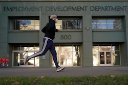 In this file photo, a runner passes the office of the California Employment Development Department in Sacramento.