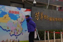 An elderly Chinese man looks at map of Chinese showing its different ethnic groups and the slogan 'Ethnic Unity' in Beijing, China Monday, Jan. 11, 2021. A Chinese official on Monday denied Beijing has imposed coercive birth control measures among Muslim minority women, following an outcry over a tweet by the Chinese Embassy in Washington claiming that government polices had freed women of the Uighur ethnic group from being 'baby-making machines.'