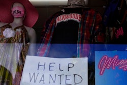 A 'Help Wanted,' sign is shown in the window of a souvenir shop, Thursday, Jan. 7, 2021, in Miami Beach, Fla. Layoffs spiked in November compared with the previous month and the number of job openings slipped, a sign the job market has stalled as the resurgent coronavirus has forced new shutdowns of restaurants and bars and discouraged consumer spending.