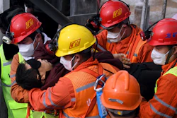In this photo released by Xinhua News Agency, rescuers carry a miner who was trapped in a mine to an ambulance in Qixia City in east China's Shandong Province.