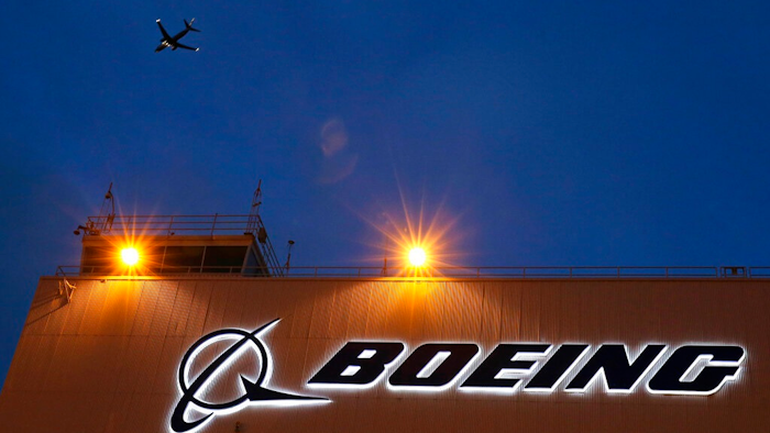 In this Oct. 19, 2015, file photo, an airplane flies over a sign at Boeing's newly expanded 737 delivery center at Boeing Field in Seattle. Federal regulators have imposed $5.4 million in civil penalties against Boeing on Thursday, Feb. 25, 2021, for violating terms of a $12 million settlement in 2015, and the aircraft maker has agreed to pay another $1.21 million to settle two current enforcement cases.