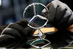 In this file photo, an employee attaches a Mercedes emblem as he works on a Mercedes-Benz S-class car at the Mercedes plant in Sindelfingen, Germany.