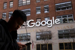 In this Dec. 17, 2018, file photo a man using a mobile phone walks past Google offices in New York. Google is closing the internal studio tasked with developing games for its Stadia cloud-gaming service, a move that raises questions about the future of its Stadia service itself. Google launched Stadia in November 2019 as a cloud-based gaming service, in deliberate contrast to pricey video-game consoles. But Google said Monday, Feb. 1, 2021 it will no longer invest in creating its own games for the service beyond any planned, near-term titles.