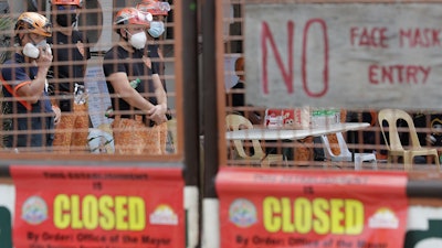Rescuers stand inside the compound of the TP Marcelo Ice Plant in Navotas, Philippines. An ammonia leak from the ice plant in the Philippine capital region left some dead and more than 90 injured or sickened.