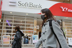 People walk by a SoftBank shop in Tokyo. Japanese telecommunications and technology conglomerate Softbank Group Corp. reported an $11 billion profit for the October-December quarter as its investments rose in value.