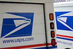 In this file photo mail delivery vehicles are parked outside a post office in Boys Town, Nebraska.