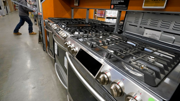This Oct. 29, 2020 file photo, a passer-by walks past stoves on display at a Home Depot location, in Boston. Orders to U.S. factories for big-ticket goods shot up 3.4% in January 2021, pulled up by surge in orders for civilian aircraft. A category that tracks business investment posted a more modest gain, the Commerce Department reported Thursday, Feb. 24.