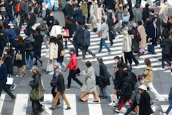 People wearing face masks to protect against the spread of the coronavirus cross a scramble intersection in Tokyo, Tuesday, March 9, 2021.