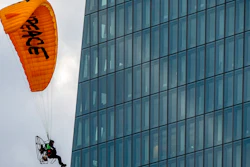 An activist of environmental organization Greenpeace flies with a motorized paraglider past the European Central Bank in Frankfurt, Germany, Wednesday, March 10, 2021. Two activists landed on the roof of a side building and unrolled a banner to protest against the ECB's climate policy.