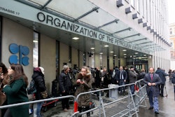 In this file photo taken before the coronavirus pandemic restrictions, people stand outside the headquarters of the Organization of the Petroleum Exporting Countries, OPEC, in Vienna, Austria.