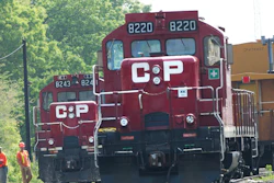 In this May 23, 2012, file photo, surveyors work next to Canadian Pacific Rail trains which are parked on the train tracks in Toronto.