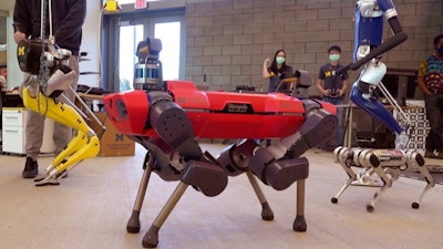 In a frame grab from video, robots walk across the floor of the University of Michigan's Ford Motor Co. Robotics Building, March 12, 2021 in Ann Arbor, Mich. The four-story, $75 million, 134,000-square-foot complex has three floors that house classrooms and research labs for robots that fly, walk, roll and augment the human body.