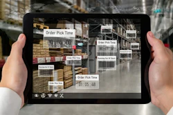 Person holding iPad looking at warehouse.