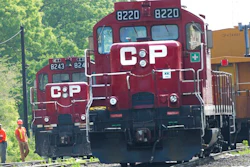 In this May 23, 2012 file photo, surveyors work next to Canadian Pacific Rail trains which are parked on the train tracks in Toronto.