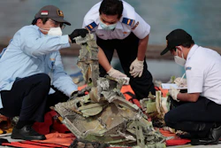 Investigators inspect a pieces of Sriwijaya Air flight SJ-182 retrieved from the Java Sea, Tanjung Priok Port, Jakarta, Jan. 21, 2021.