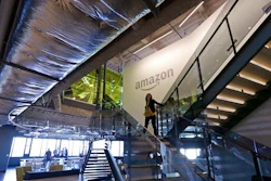 In this Sept. 27, 2017, file photo, an Amazon worker walks down steps in a company office before an event announcing several new Amazon products by the company in Seattle. Amazon plans to have its employees return to the office by fall as the tech giant transitions away from the remote work it implemented for many workers due to the coronavirus pandemic. On Tuesday, March 30, 2021, the company told employees it is planning a 'return to an office-centric culture as our baseline.'