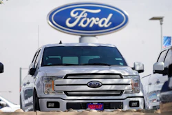 In this Sunday, Oct. 11, 2020, file photo, a row of 2020 sports-utility vehicles pickup trucks sits at a Ford dealership, in Denver. Ford Motor Co. says it made $3.26 billion in the first quarter, helped by rising vehicle prices and in spite of production cuts due to a global shortage of computer chips. The earnings reversed a nearly $2 billion net loss from a year ago, when Ford burned through cash at the start of the coronavirus pandemic.