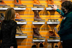 In this March 18, 2021 file photo, a salesperson helps a customer shopping for Bean Boots at the L.L. Bean flagship retail store in Freeport, Maine. Newly vaccinated and armed with $1,400 stimulus checks, Americans went on a spending spree last month, buying new clothes and going out to eat again. Retail sales surged a seasonally adjusted 9.8% after dropping about 3% the month before, the Commerce Department said Thursday, April 15.