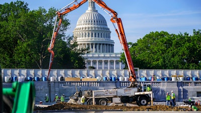 A concrete pump frames the Capitol Dome during renovations and repairs to Lower Senate Park on Capitol Hill in Washington, May 18, 2021.