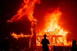 In this Nov. 8, 2018 file photo, a home burns as a wildfire called the Camp Fire rages through Paradise, Calif. A trust approved by a federal judge to help compensate victims of deadly California wildires sparked by Pacific Gas & Electric equipment paid survivors just $7 million while racking up $51 million in overhead in its first year of operation, KQED News reported.