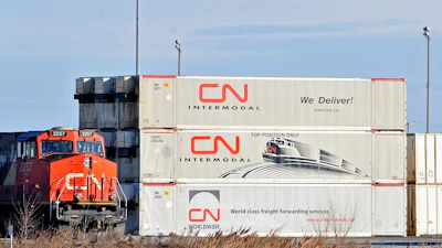 A Canadian National locomotive passes by freight containers at the Canadian National Taschereau yard in Montreal, Saturday, Nov. 28, 2009. Canadian National sweetened its offer to buy Kansas City Southern railroad Thursday, May 13, 2021, and derailed rival Canadian Pacific’s bid for the railroad that handles traffic in the United States and Mexico.