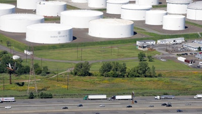 In this Sept. 8, 2008 file photo traffic on I-95 passes oil storage tanks owned by the Colonial Pipeline Company in Linden, N.J. A major pipeline that transports fuels along the East Coast says it had to stop operations because it was the victim of a cyberattack. Colonial Pipeline said in a statement late Friday that it “took certain systems offline to contain the threat, which has temporarily halted all pipeline operations, and affected some of our IT systems.”