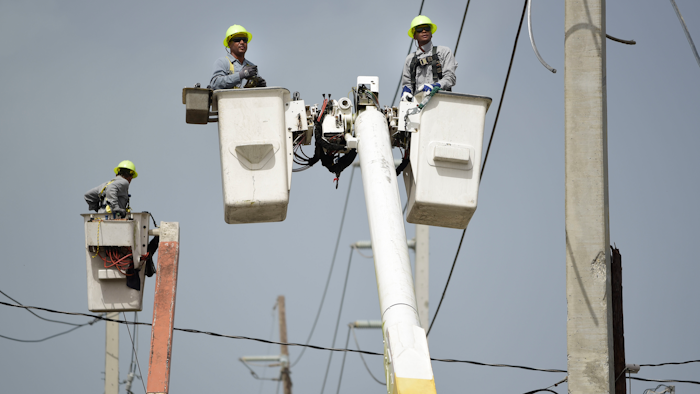 In this Oct. 19, 2017 file photo, Puerto Rico Electric Power Authority workers repair distribution lines damaged by Hurricane Maria in the Cantera community of San Juan, Puerto Rico. Luma, the private company that took over power transmission and distribution in June 2021 has struggled with widespread outages, affecting more than 1 million customers so far in its first two weeks.