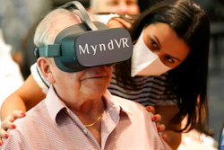 Gloria Gantes, right, monitors Terry Colli, a resident of John Knox Village, as he participates in a virtual reality study, June 1, 2021, Pompano Beach, Fla.