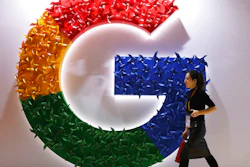 A woman walks past the logo for Google at the China International Import Expo in Shanghai, Nov. 5, 2018.