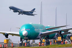 In this April 23 photo, a U.S. Air Force KC-46A Pegasus jet takes off in view of a line of Boeing 777X jets parked nose to tail on an unused runway at Paine Field, near Boeing's massive production facility in Everett, Wash.