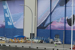 In this Monday, March 23, 2020, file photo, a worker walks near a mural of a Boeing 777 airplane at the company's manufacturing facility in Everett, Wash., north of Seattle.