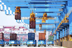 Gantry cranes move containers onto transporters at a port in Qingdao, China, June 4, 2021.