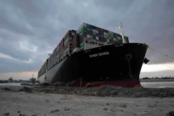 In this March 28, 2021 photo, released by the Suez Canal Authority, tug boats and diggers work to free the Panama-flagged, Japanese-owned Ever Given, which is lodged across the Suez Canal.