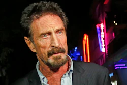 In this Dec. 12, 2012, file photo, anti-virus software founder John McAfee answers questions to reporters as he walks on Ocean Drive, in the South Beach area of Miami Beach, Fla. McAfee, the outlandish security software pioneer who tried to live life as a hedonistic outsider while running from a host of legal troubles, was found dead in his jail cell near Barcelona, Spain, on Wednesday, June 23, 2021. His death came just hours after a Spanish court announced that it had approved his extradition to the United States to face tax charges punishable by decades in prison, authorities said.