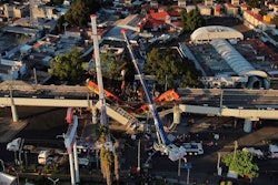 In this May 4, 2021 file photo, subway cars dangle at an angle from a collapsed elevated section of the metro in Mexico City, the day after the collapse. A preliminary report on June 16, 2021, by experts into the collapse that killed 26 people placed much of the blame on poor welds in studs that joined steel support beams to a concrete layer supporting the trackbed.