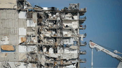 A parked crane sits beside the still standing section of Champlain Towers South, which partially collapsed last Thursday, as rescue efforts on the rubble below were paused out of concern about the stability of the remaining structure, Thursday, July 1, 2021, in Surfside, Fla. Scores of residents are still missing one week after the seaside condominium building partially collapsed.