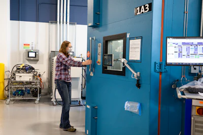 Mary Fredrick, Ford Motor Co. battery validation engineer, opens the doors to a thermal chamber used to soak battery packs at extreme temperatures to validate their performance before production, at Ford’s Battery Benchmarking and Test Laboratory in Allen Park, Michigan.