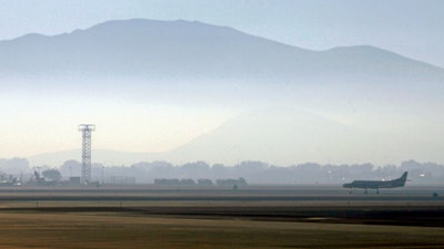 In this Sept. 24, 2014 file photo, smoke hangs over Reno-Tahoe International Airport as a plane takes off in Reno, Nev. A shortage of jet fuel, coupled with supply chain issues and an urgent demand from firefighting aircraft, continues to cause problems at airports around the West.