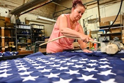 Debbie Wademan, production supervisor, cuts the stars to proper length to make American flags at North American Manufacturing on June 28 in Scranton, Pa.