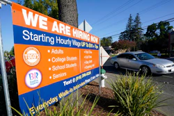 A car passes a hiring banner in Sacramento, Calif., Friday, July 16, 2021. Hiring in California slowed down in June 2021 as employers in the nation's most populous state tried to coax reluctant workers back into their pre pandemic jobs before the nation's expanded unemployment benefits expire in September.