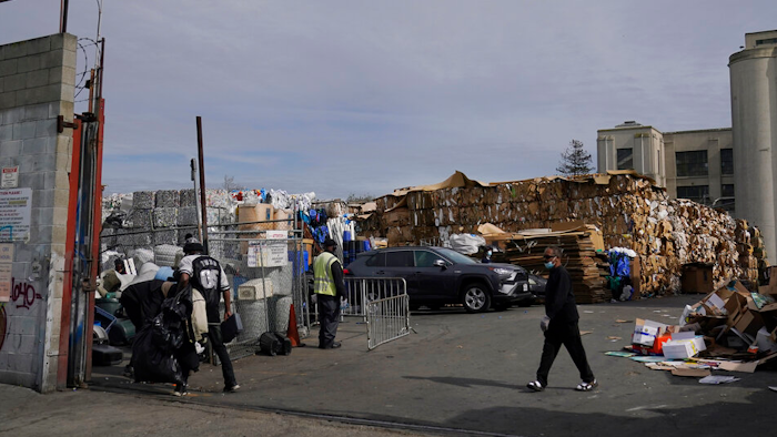 In this Feb. 18, 2021 photo, people walk inside a recycling location in Oakland, Calif.