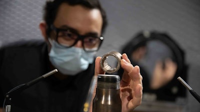 University of Cincinnati student Mohammad Saleem holds one of the novel jet engine nozzles UC designed in professor Ephraim Gutmark's lab. The U.S. Navy will test UC's design on F-18 Super Hornets this fall.