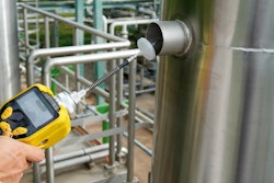 An EPA environmental officer using a chemical detector to test for VOC levels in a factory.