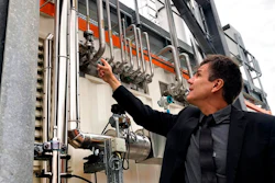 Dietrich Brockhagen, Executive Director of Atmosfair, points on pipes of the system that brings hydrogen and carbon into the facility that mix them and produce e-fuel at the 'Atmosfair' synthetic kerosene plant in Werlte, Germany, Monday, Oct. 4, 2021. German officials are unveiling a facility in Werlte, near Germany's northwestern border with the Netherlands, what they say will be the world's first commercial plant for making synthetic kerosene as part of an effort to reduce the climate impact of flying.