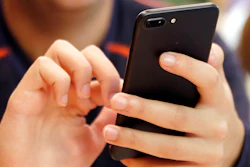 In this Sept. 16, 2017, file photo, a person uses a smart phone in Chicago. Most Americans across party lines have serious concerns about cyber attacks on U.S. computer systems and view China and Russia as major threats. That's according to a new poll by The Pearson Institute and the Associated Press-NORC Center for Public Affairs Research